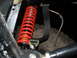 1994 Jeep YJ - Close-up view of a red coilover shock absorber and a tire, likely from an off-road vehicle.