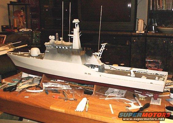 Model ship on a wooden table with crafting supplies