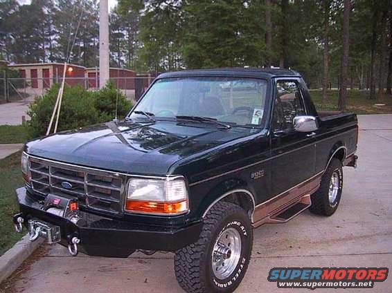 Dark green two-door Ford Bronco with aftermarket bumper and winch, viewed from the front three-quarter angle