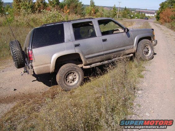 Silver SUV on dirt road, spare tire mounted on rear bumper. Appears to be a 1995 model