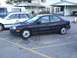 2003 Ford Ranger - A dark sedan is parked in a lot next to other vehicles.