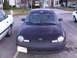 2003 Ford Ranger - A dark sedan is parked in a lot, showing its front end and license plate.