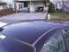 2003 Ford Ranger - A dark blue car's roof is visible in the foreground, with a residential driveway and house in the background.