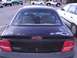 2003 Ford Ranger - The rear of a black Dodge Neon is shown with visible paint damage and other cars in the background.
