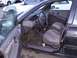 2003 Ford Ranger - The interior of a sedan is shown, with a view of the dashboard, steering wheel, and front seats. Other vehicles are parked nearby.