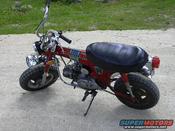 Red 1972 Honda CT70 Trail Bike parked on a gravel surface