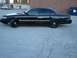 1992 Ford Crown Victoria - A black 1992 Ford Crown Victoria sedan is parked on asphalt, with another white car in the background.