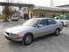 1998 BMW 7 Series - A silver 1998 BMW 7 Series sedan is parked outside a building, with other vehicles visible in the background.