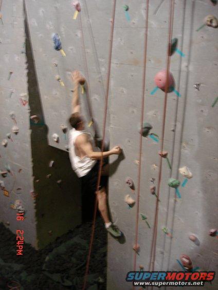 Indoor climbing wall with a person ascending, ropes visible. Timestamp 01/16 2:24PM