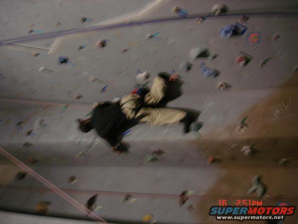 Climber on indoor wall with colorful holds