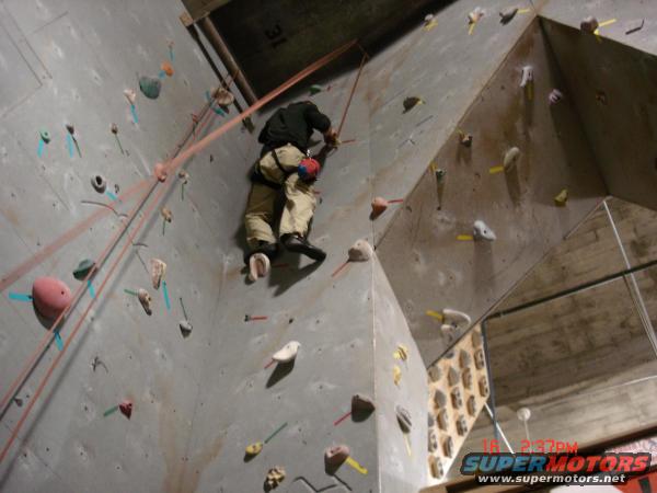 Indoor climbing wall with a person ascending, timestamp 18:2:37 PM