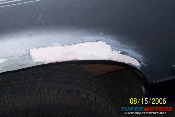close-up of body filler on wheel well of a vehicle