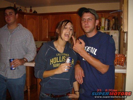 People gathered in a kitchen, one holding a can