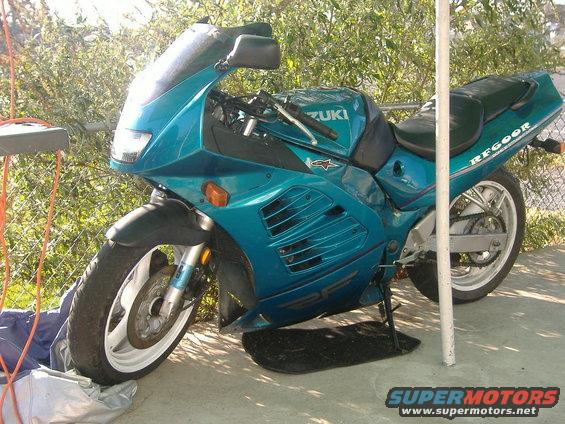 Teal Suzuki motorcycle with black seat and "RF600R" text on the tail, parked outdoors
