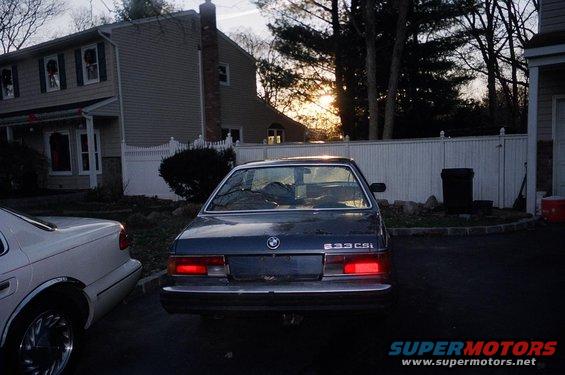 Rear view of a dark blue 1983 BMW 633CSi with a white car to its left