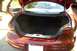 1999 Ford Taurus - The trunk of a red sedan is open, revealing the cargo area and the rear of the vehicle.