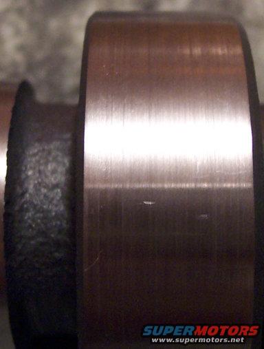 Close-up of a cylindrical metal part with brushed finish and black textured section