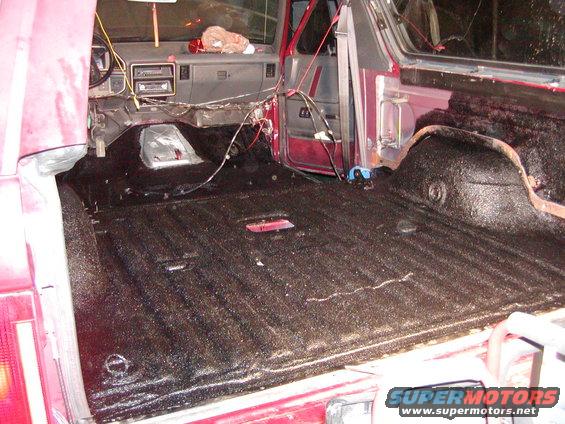 Red SUV interior with black spray-in bed liner and exposed wiring