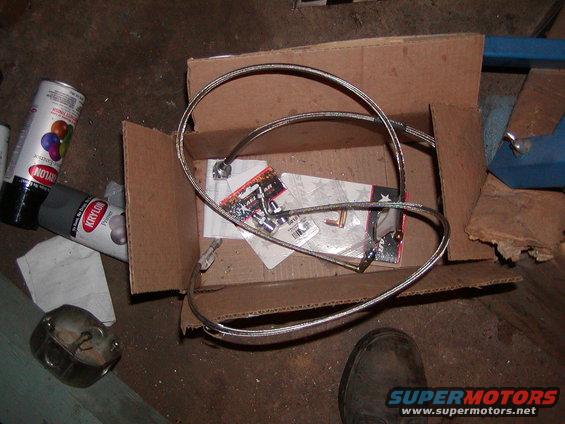 Braided steel brake lines and fittings in a cardboard box with Krylon spray cans nearby