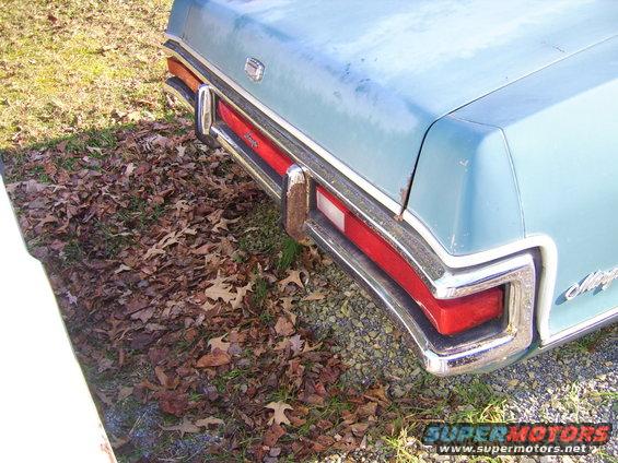 Rear quarter of a light blue 1971 Mercury Marquis with chrome bumper and red taillights