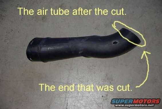 Black rubber air intake tube with a cut end, marked with yellow circles and arrows