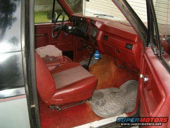 1986 Ford Bronco interior, red seats and dashboard, driver's side view