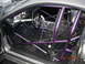 1990 Ford Mustang - Interior view of a modified car a prominent purple roll cage and racing bucket seats.