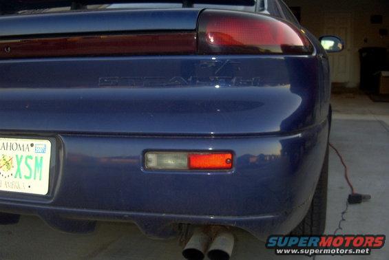Rear of blue sports car with Oklahoma license plate XSM. Exhaust pipes visible