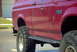 1994 Ford Bronco - Side view of a red 1994 Ford Bronco XL with aftermarket wheels and tires.