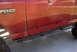 1994 Ford Bronco - The side of a red Ford Bronco XL is shown with aftermarket sliders installed.