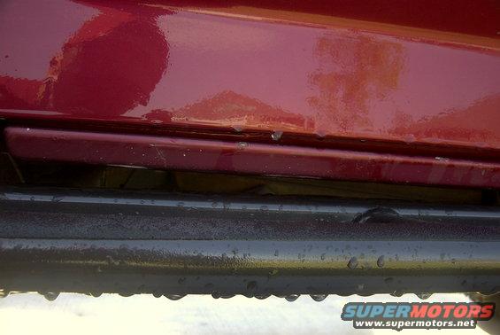Red vehicle body over black slider with water droplets