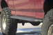 1994 Ford Bronco - Close-up of a 1994 Ford Bronco's side, highlighting its rock sliders and off-road tires.
