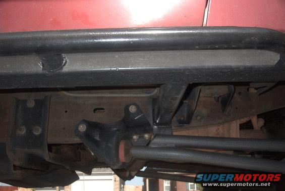 Red vehicle with black rock sliders and undercarriage detail