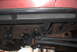 1994 Ford Bronco - Undercarriage view of a red vehicle, highlighting the black rock sliders and suspension components.