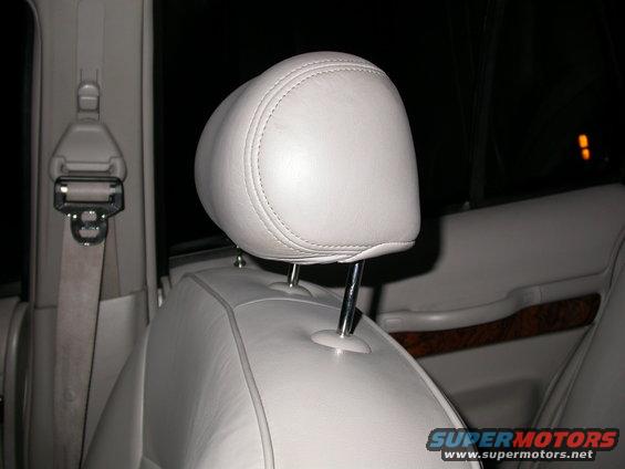 Light-colored leather headrest and seatbelt in a car interior