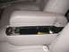 1998 Mercury Grand Marquis - The interior of a car shows an open armrest compartment with coins and a pen.