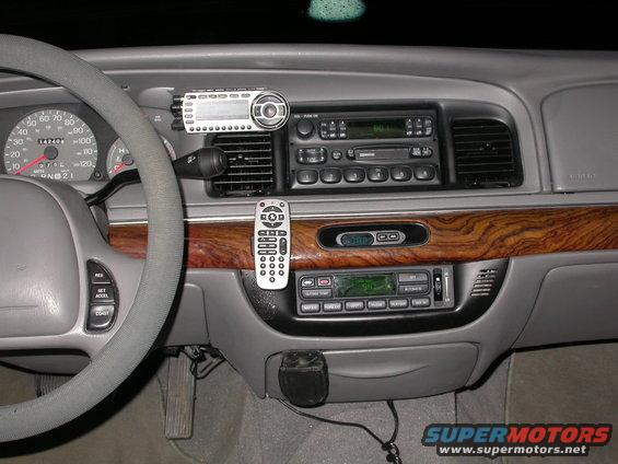 1998 Mercury Grand Marquis dashboard showing steering wheel, instrument cluster, aftermarket stereo, and remote control