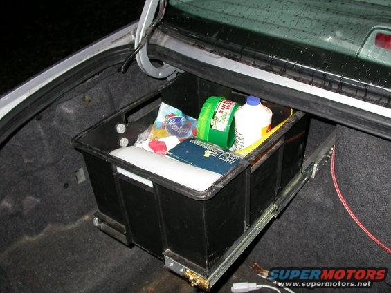 Trunk organizer pulled out, containing cleaning supplies like Turtle Wax and Ocean Spray
