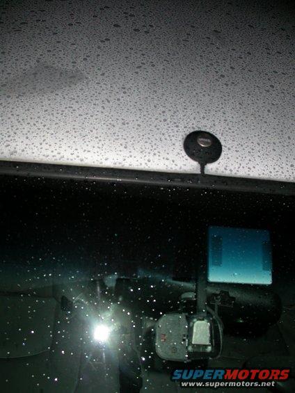 Interior view of a car with rain on the windshield and a dashcam mounted