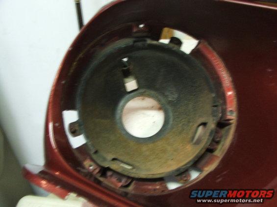 Red car headlight mounting bucket with rust and mounting holes