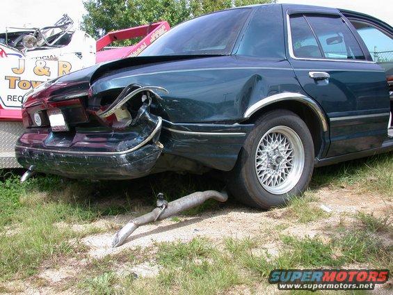 1997 Mercury Grand Marquis rear end heavily damaged, detached exhaust pipe on ground