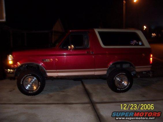 Side view of a red and tan 1994 Ford Bronco with a body lift