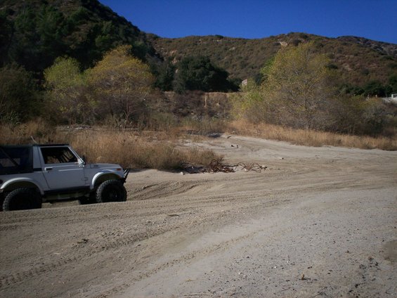 White 1987 Suzuki Samurai convertible SUV on sandy terrain