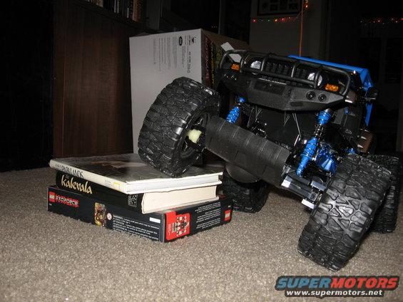 Blue toy truck with large tires on a stack of books