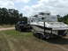 2006 Volkswagen Jetta - A truck is parked on grass, towing a boat on a trailer, with an RV parked behind the boat.