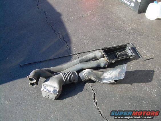air intake hoses and air filter box on asphalt
