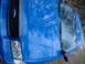1998 Ford Crown Victoria - Blue Ford F-150 truck front corner is partially covered by a blue tarp.