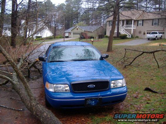 1998 Ford Crown Victoria parked on driveway with fallen tree branches blocking the front