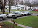 2003 Ford Crown Victoria - A silver 2003 Ford Crown Victoria is parked in a suburban driveway next to another car.