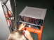 2003 Yamaha BIG BEAR - A person connects cables to the rear panel of stacked audio receivers, with a red tool in hand.